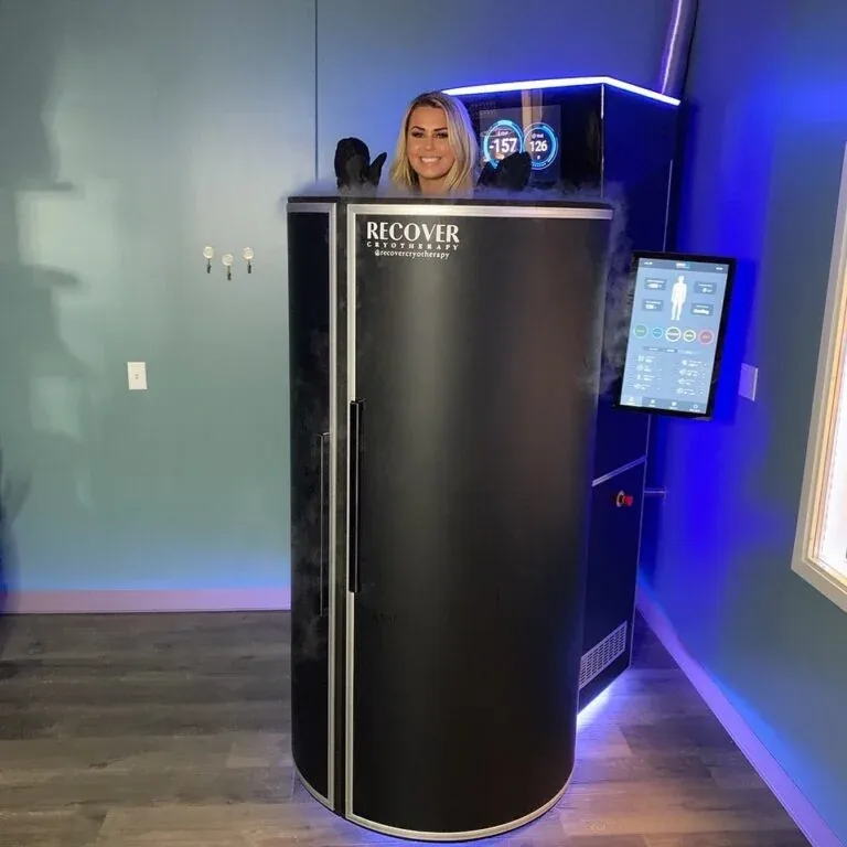 Woman using a full-body cryotherapy chamber at The Rectory Clinic for wellness, recovery, and cold therapy treatment.